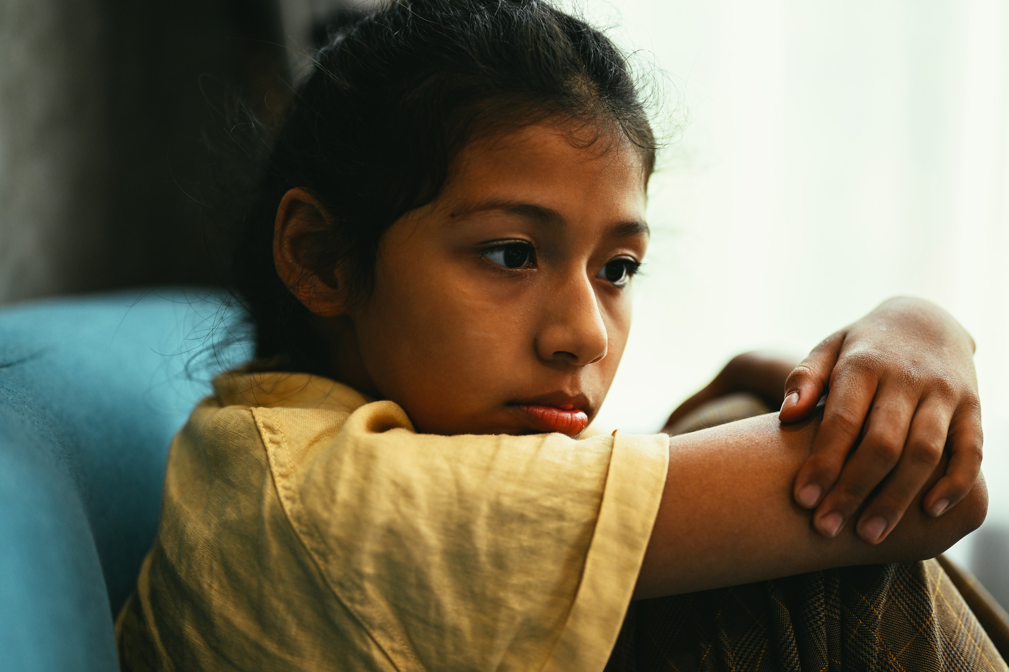 A pensive young girl stares off in the distance.